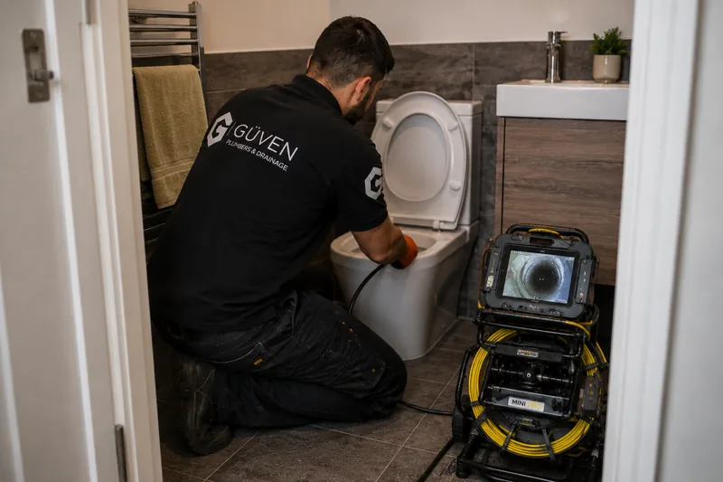 Güven drainage engineer using inspection equipment at a toilet